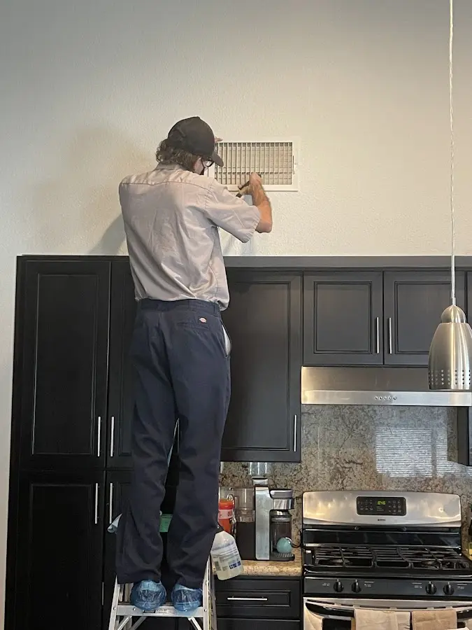 Technician inspecting an air vent during HVAC service in Prairie du Chien
